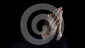 Man Praying Hands in black background. Close up