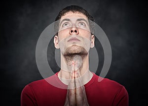 Man praying with hands clasped.