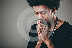 Man praying hands clasped hoping for best asking for forgiveness or miracle