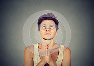 Man praying hands clasped hoping for best asking for forgiveness