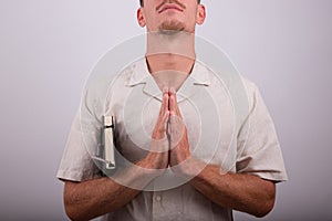 Man with praying hands isolated on white background. Religious man during a prayer, believing person meditates