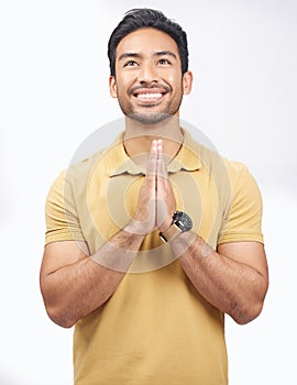 Man, praying hands and studio with looking up, smile and communication with God by white background. Student, prayer and