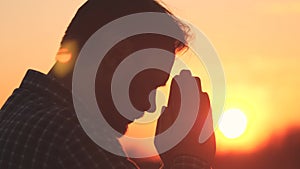 Man praying, man folded her hands in prayer silhouette at sunset. slow motion video lifestyle, man folded her hands in