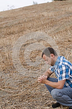 Man praying on the side of a hill.