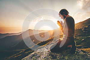 Man praying at sunset mountains