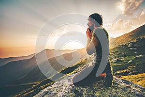 Man praying at sunset mountains Travel Lifestyle