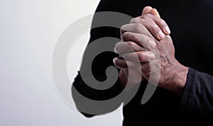 Man praying to god with hands together Caribbean man praying with grey background stock photo
