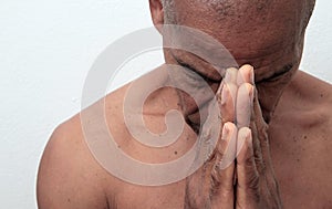 Man praying to god with hands together Caribbean man praying with grey background stock photo