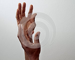 Man praying to god with hands together Caribbean man praying with grey background stock photo