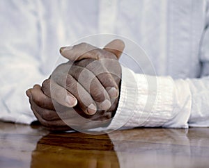 man praying to God worshipping with hands together Caribbean man praying with people stock image stock photo