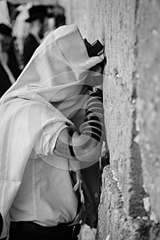 Man praying at the wailing wall, in black and white