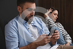 Man preferring smartphone over his girlfriend at home. Relationship problems