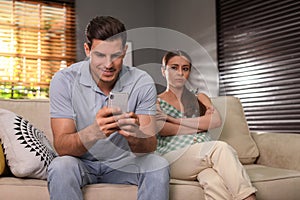 Man preferring smartphone over spending time with his girlfriend. Jealousy in relationship photo