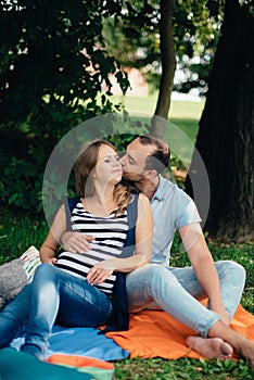 Man and pregnant woman, in an amorous couple in the park