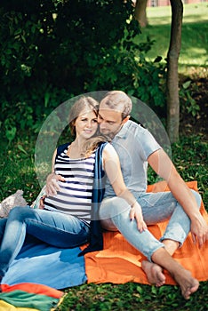 Man and pregnant woman, in an amorous couple in the park