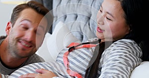 Man and pregnant woman discussing over sonography in bedroom 4k