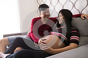 Man and pregnant woman in living room