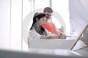 Man and pregnant woman looking at baby crib