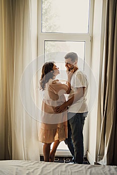 man and a pregnant woman& x27;s by the window.