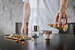 Man prepare chinese tea in glass infuser at home kitchen