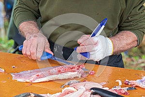 Man prepare a fresh fish by gutting and filleting.