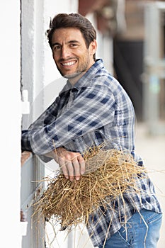 man prepares hay for animal feed in winter