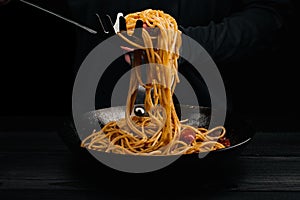 A man prepares pasta with spaghetti, tomatoes and spices