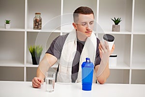 Man prepares a protein shake in the shaker after training