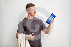 Man prepares a protein shake in the shaker after training