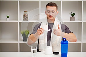 Man prepares a protein shake in the shaker after training.
