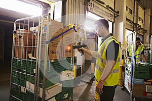 Man prepares and scans packages in a warehouse for delivery