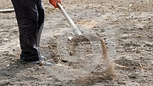 Man prepares soil for gardening with showel