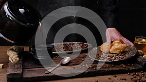 Man prepares, tea with croissants. Close-up 4k video shooting, dark background