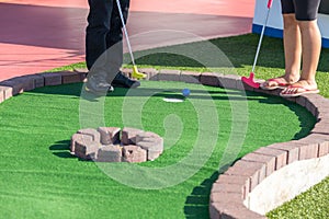 A man prepares to hit a ball during mini golf game