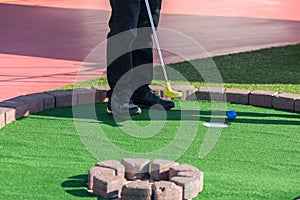 A man prepares to hit a ball during mini golf game