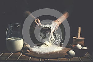 Man preparing bread dough on wooden table in a bakery close up. Preparation of Easter bread.