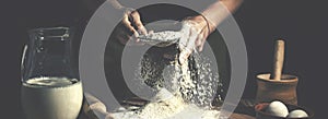 Man preparing bread dough on wooden table in a bakery close up. Preparation of Easter bread.