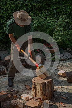 Man preparing firewood with a splitting wedge