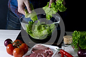 Man is preparing green salad of romaine lettuce. Healthy food concept