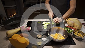 Man preparing healthy meal at home in kitchen with chicken and vegetables