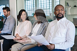 Man preparing for his interview while waiting with other applicants
