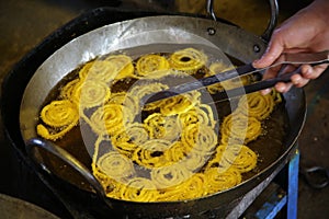 Man preparing jalebi in a frying pan