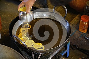 Man preparing jalebi in a frying pan