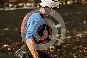 Man preparing for kayak tour on a mountain river