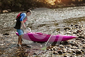 Man preparing for kayak tour on a mountain river