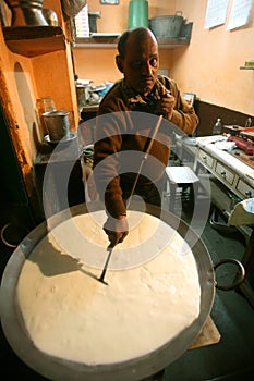 Man preparing kheer at sweetshop, delhi,