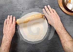 Man preparing pizza dough in bakery, top view