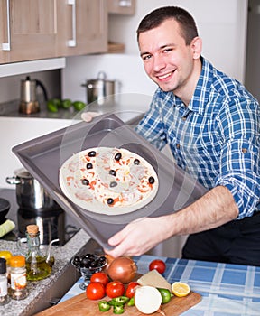 Man preparing pizza in kitchen