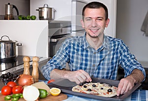 Man preparing pizza in the kitchen at home