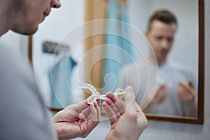 Man preparing silicon tray for teeth whitening